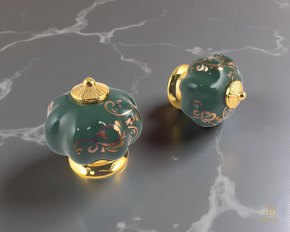 Belnua - Top and right view of luxury Tavira gold base with green porcelain cabinet knob pair with delicate golden vine cascade motif on grey marble kitchen surface