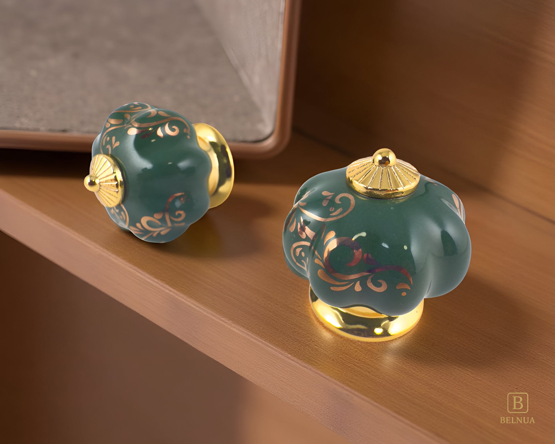 Belnua - Top and left side view of luxury Tavira green porcelain cabinet knob pair with delicate golden vine cascade motif inserted gold metal base featuring on ligth oak book shelf