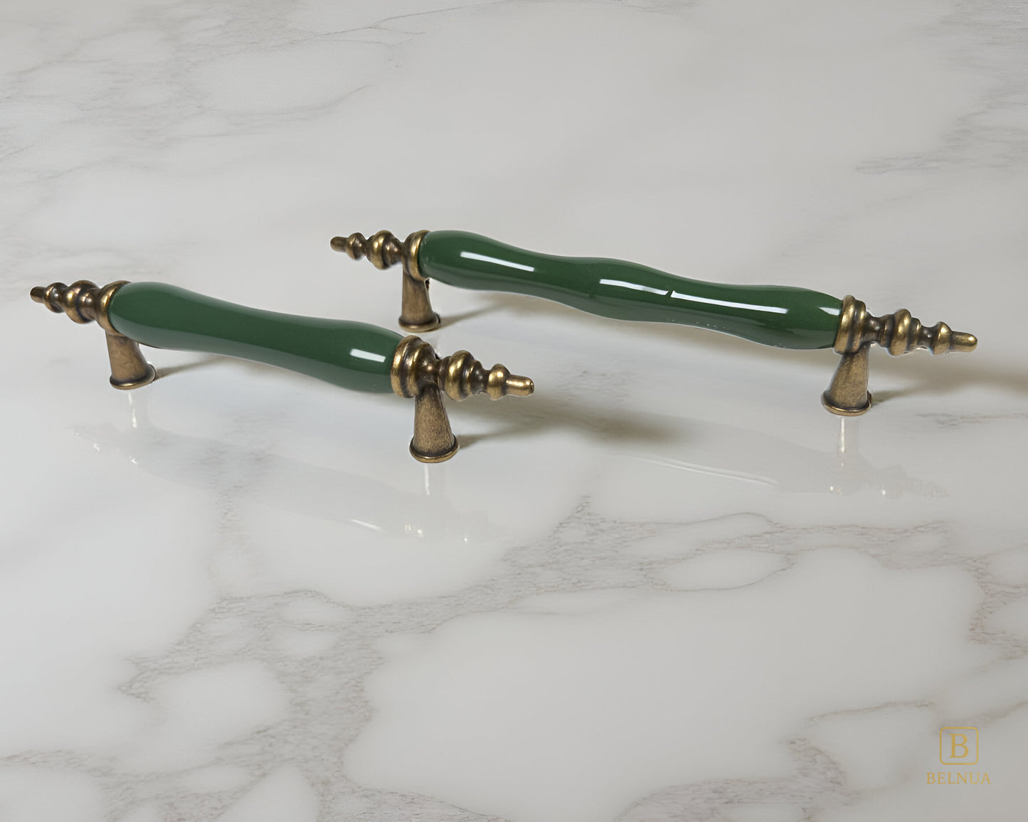 Belnua - Pair of dark green ceramic/porcelain cabinet handles with antique brass accents on a marble surface from Velnoa collection