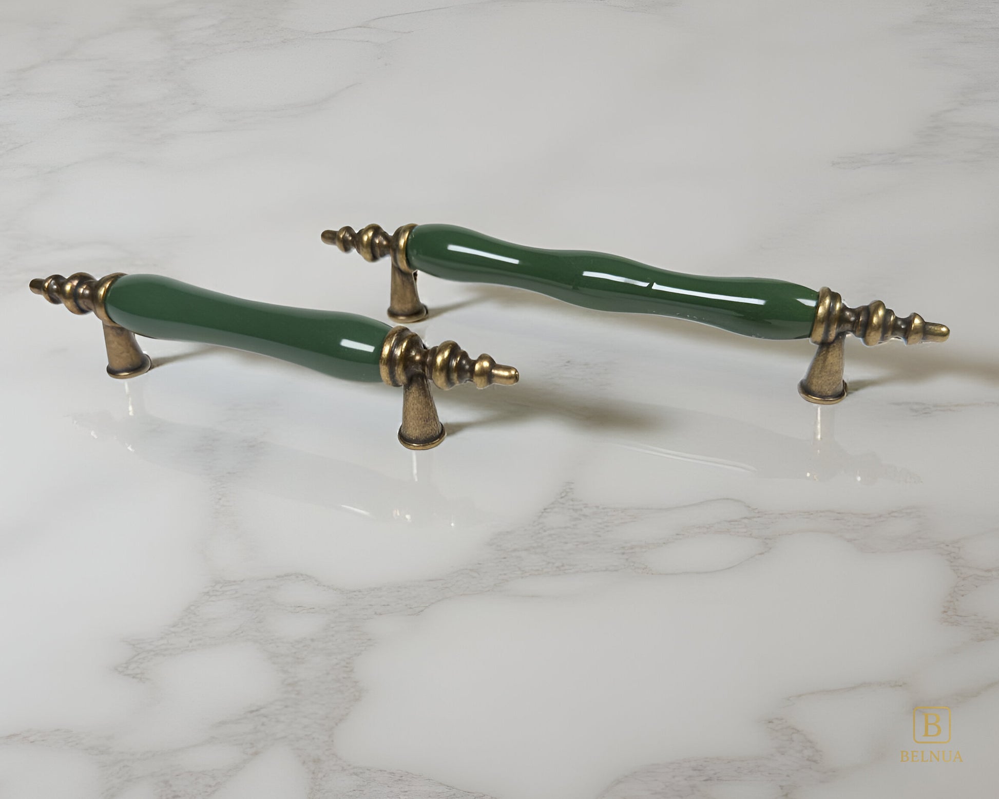 Belnua - Pair of dark green ceramic/porcelain cabinet handles with antique brass accents on a marble surface from Velnoa collection