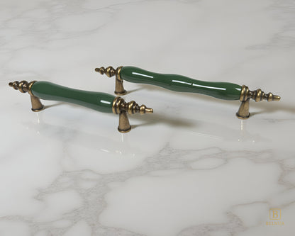 Belnua - Pair of dark green ceramic/porcelain cabinet handles with antique brass accents on a marble surface from Velnoa collection