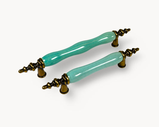 Belnua - Left side view of VELNOA cabinet handle pair in antique brass finish with turquoise porcelain insert
