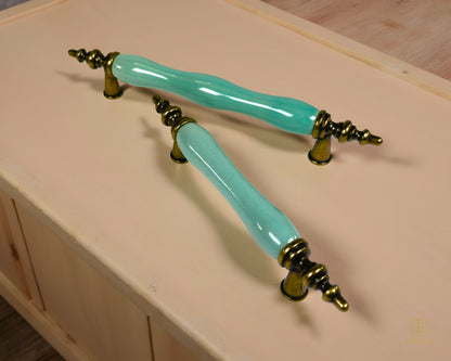 Belnua - Pair of VELNOA cabinet handle in antique brass finish with turquoise porcelain insert with wooden cabinet under day light