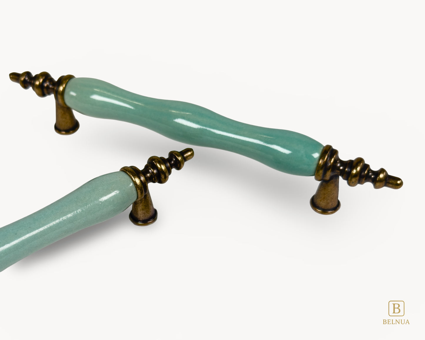 Belnua - Close up view of VELNOA cabinet handle pair in antique brass finish with turquoise porcelain insert showing brass and ceramic details