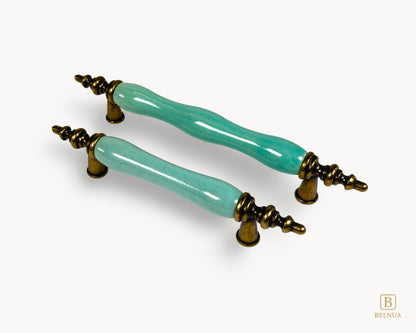 Belnua - Right side view of VELNOA cabinet handle pair in antique brass finish with turquoise porcelain insert