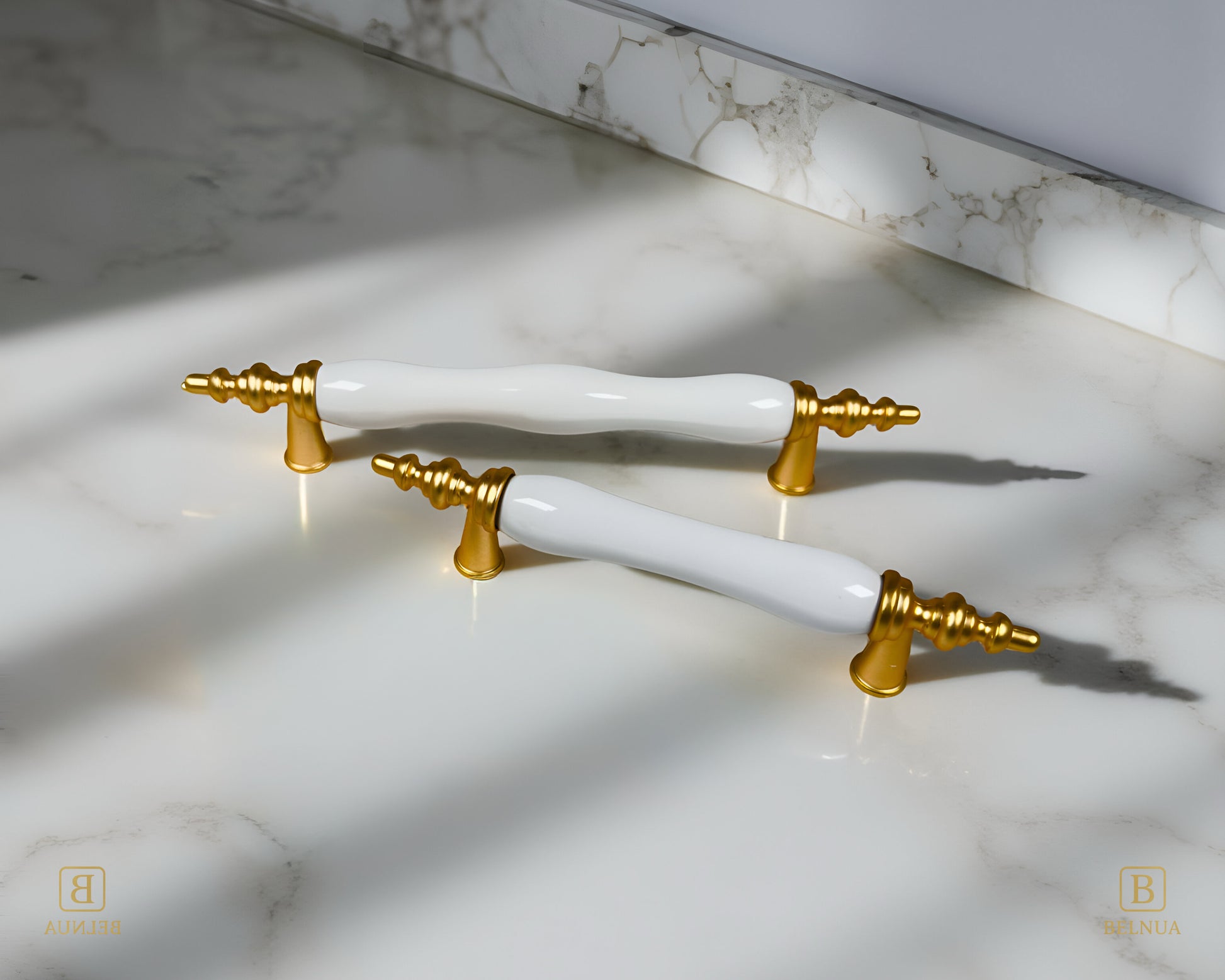 Belnua - Velnoa matte gold cabinet handle pair with plain white porcelain/ceramic insert on marble surface