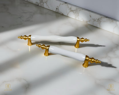 Belnua - Velnoa matte gold cabinet handle pair with plain white porcelain/ceramic insert on marble surface