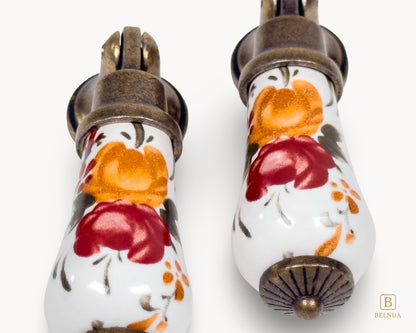 End detail of Verossa porcelain handle showing floral ceramic finish and antique brass end cap