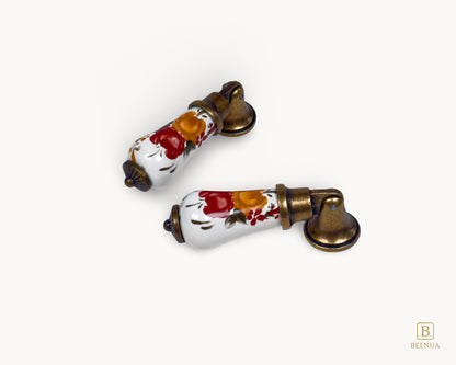 Pair of Verossa porcelain cabinet handles with antique brass finish displayed on white background