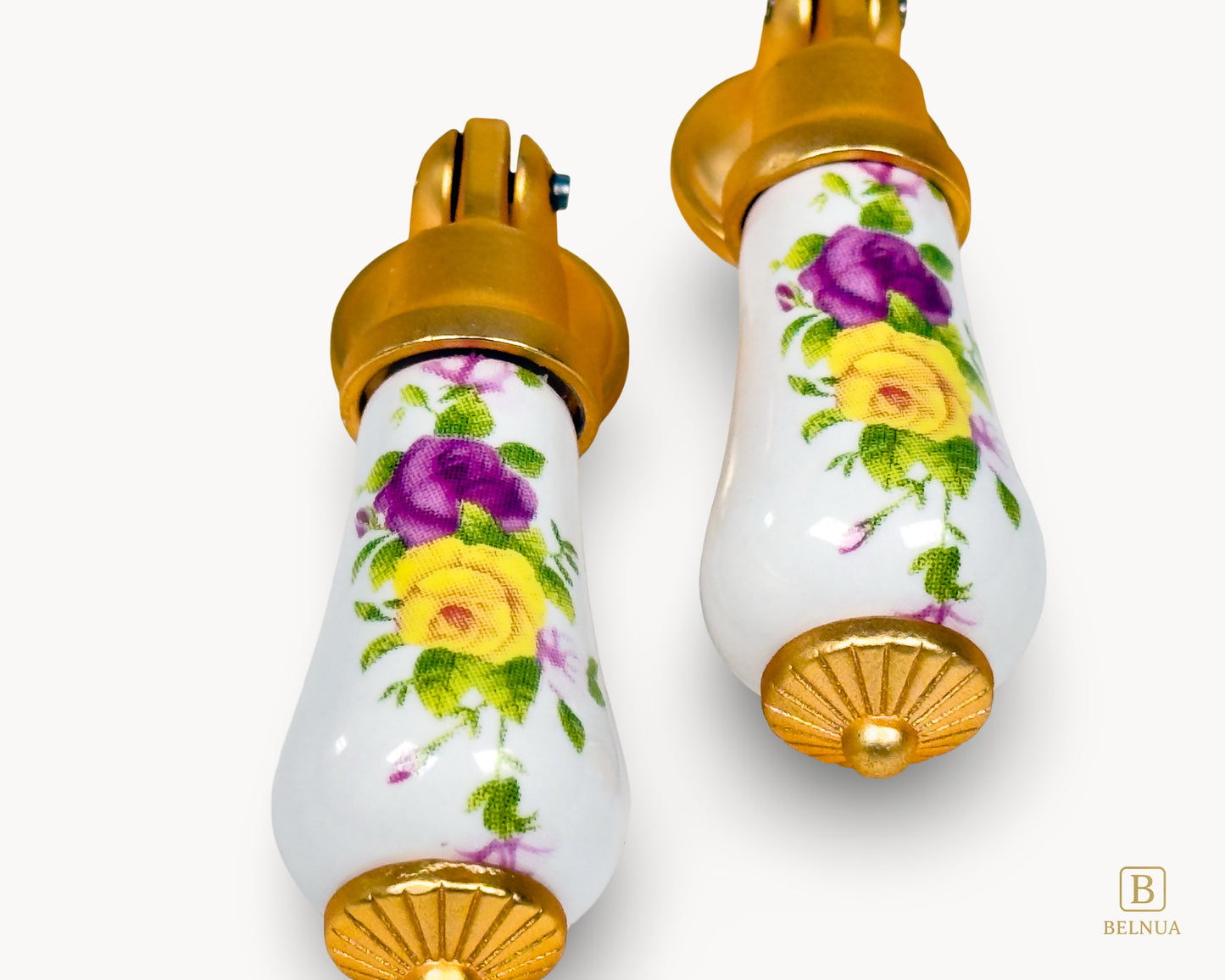 Close-up view of Verossa porcelain handle pair with floral design and satin gold base on white background.