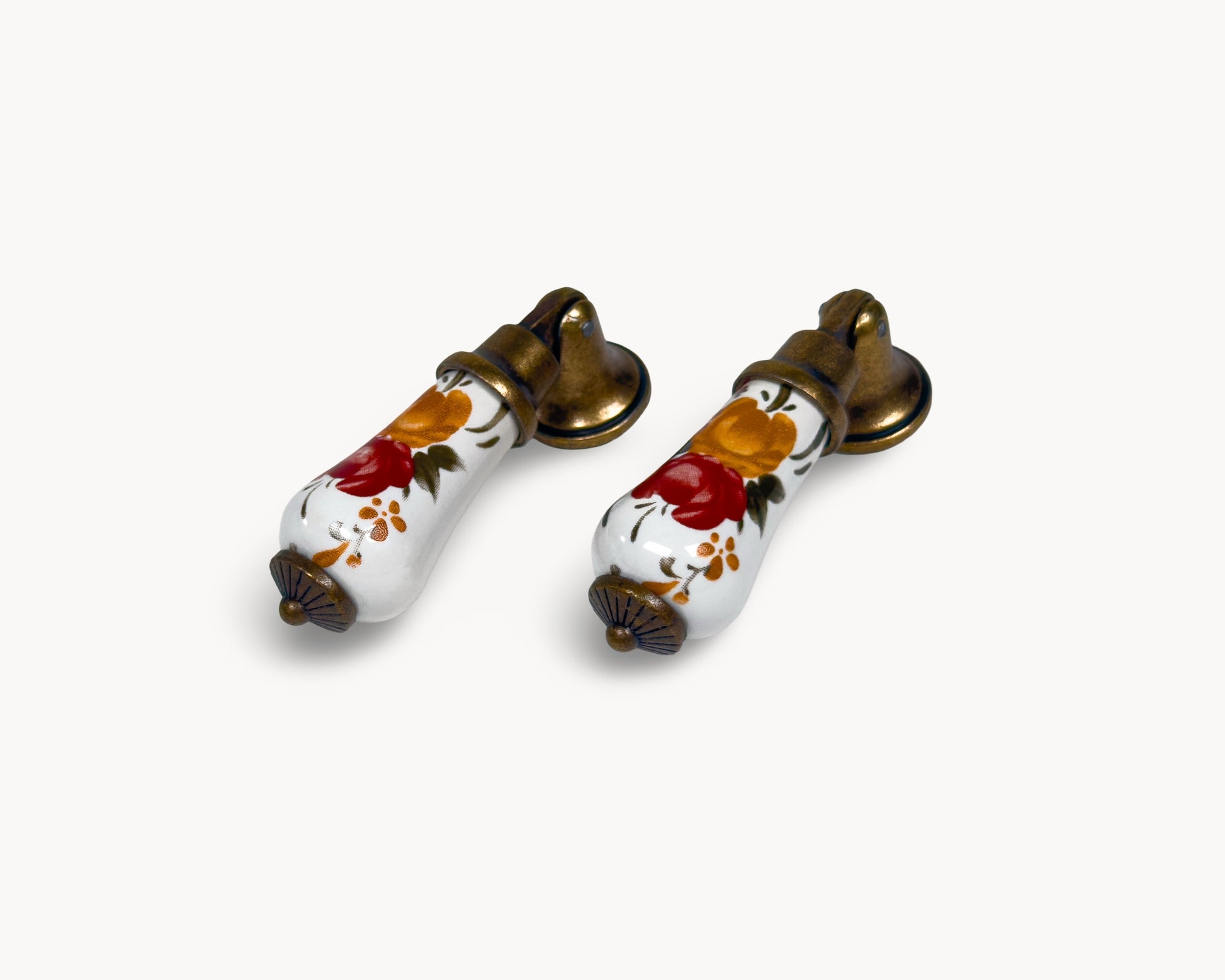 Angled front view of Verossa porcelain handle pair showing floral ceramic bodies and brass mounts