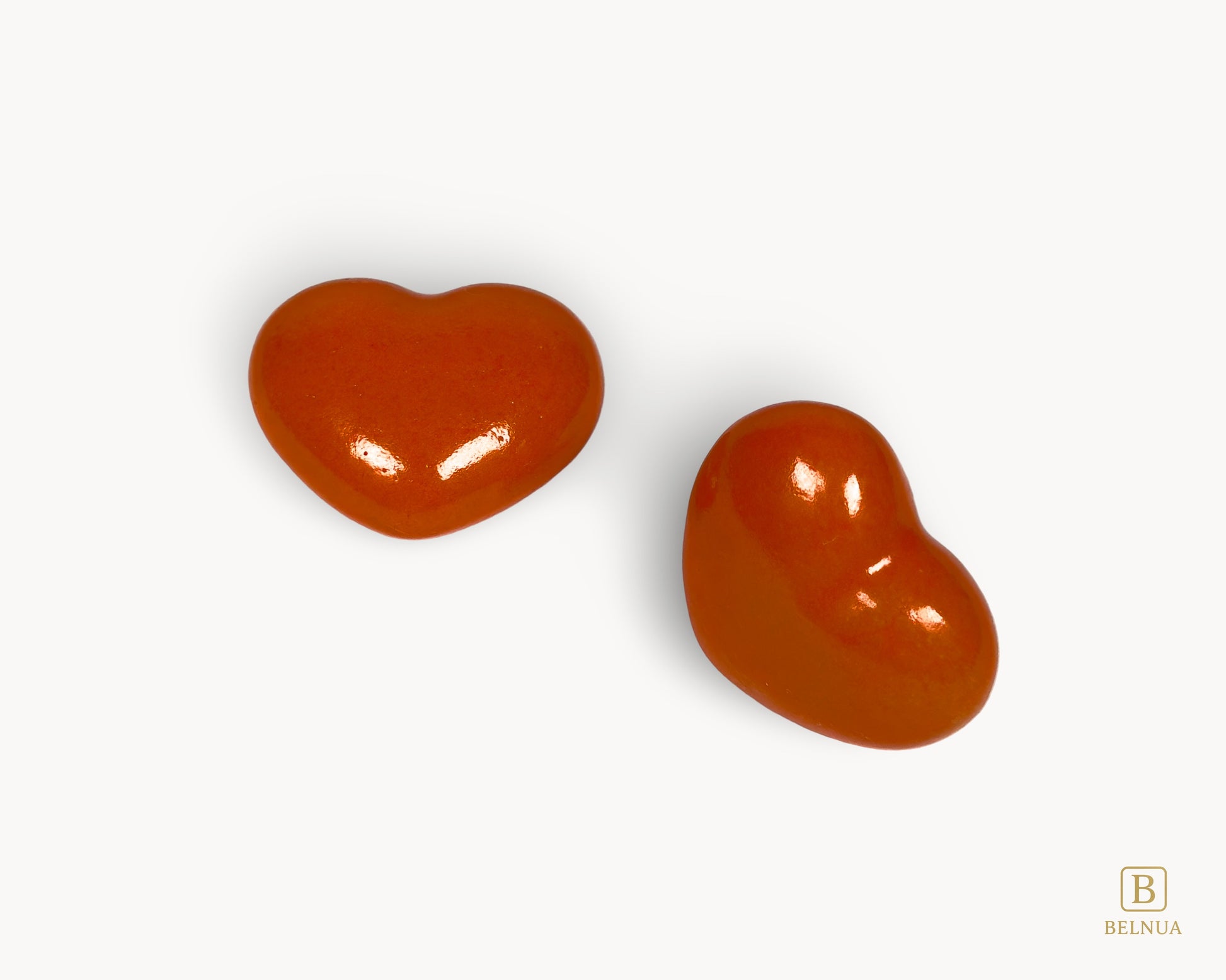 Angled pair of Belnua Veyla orange heart-shaped porcelain cabinet knobs