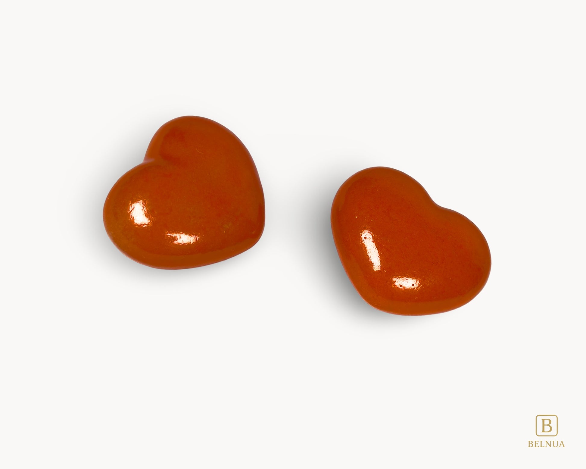 Angled view of Belnua Veyla orange heart-shaped porcelain cabinet knob