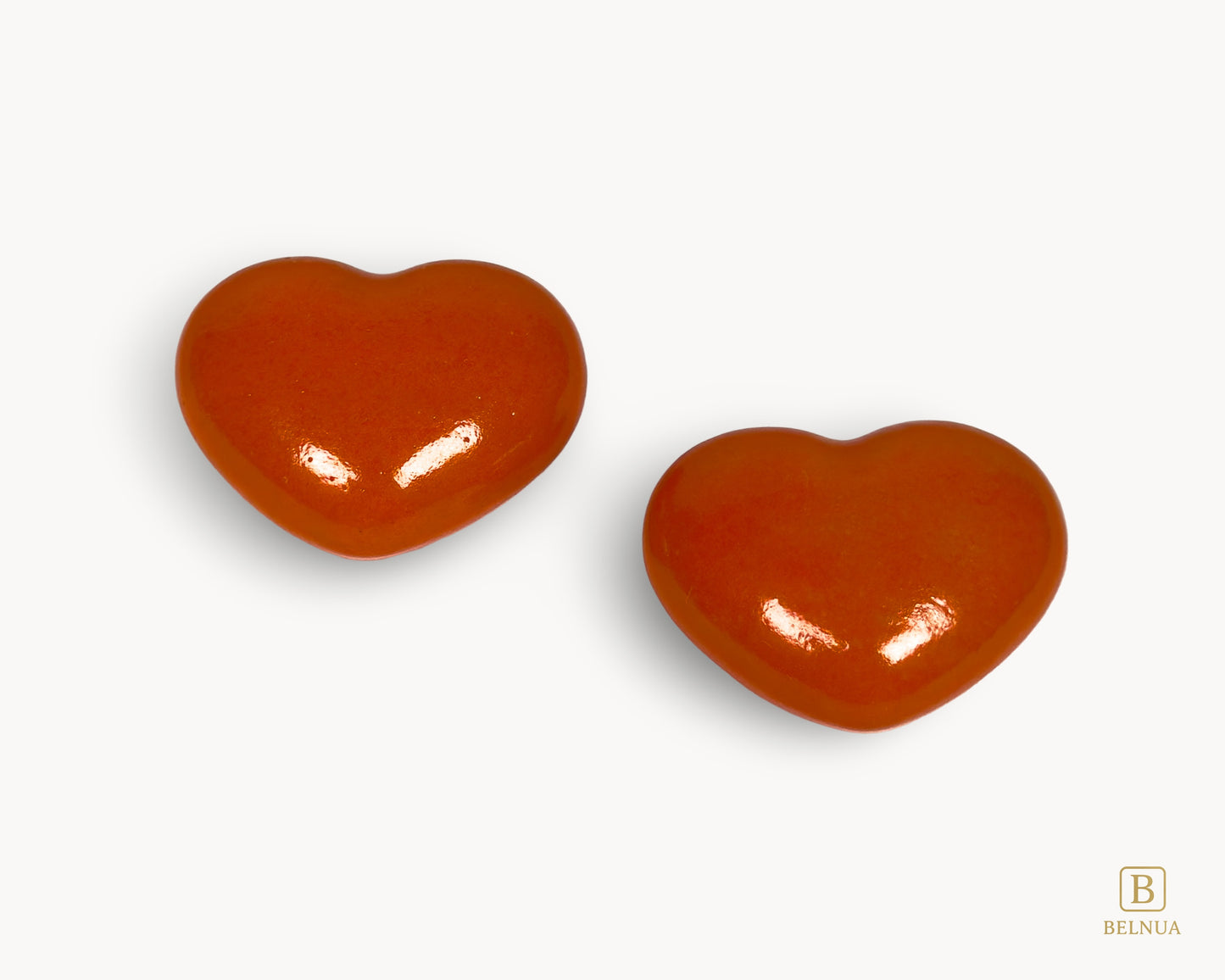 Pair of Belnua Veyla orange heart-shaped porcelain cabinet knobs, front view
