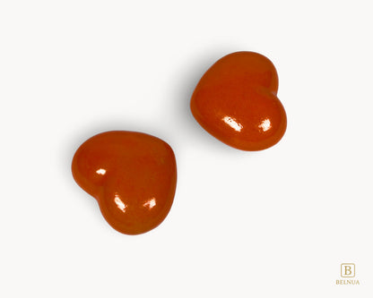 Side view of two Belnua Veyla orange heart-shaped porcelain knobs