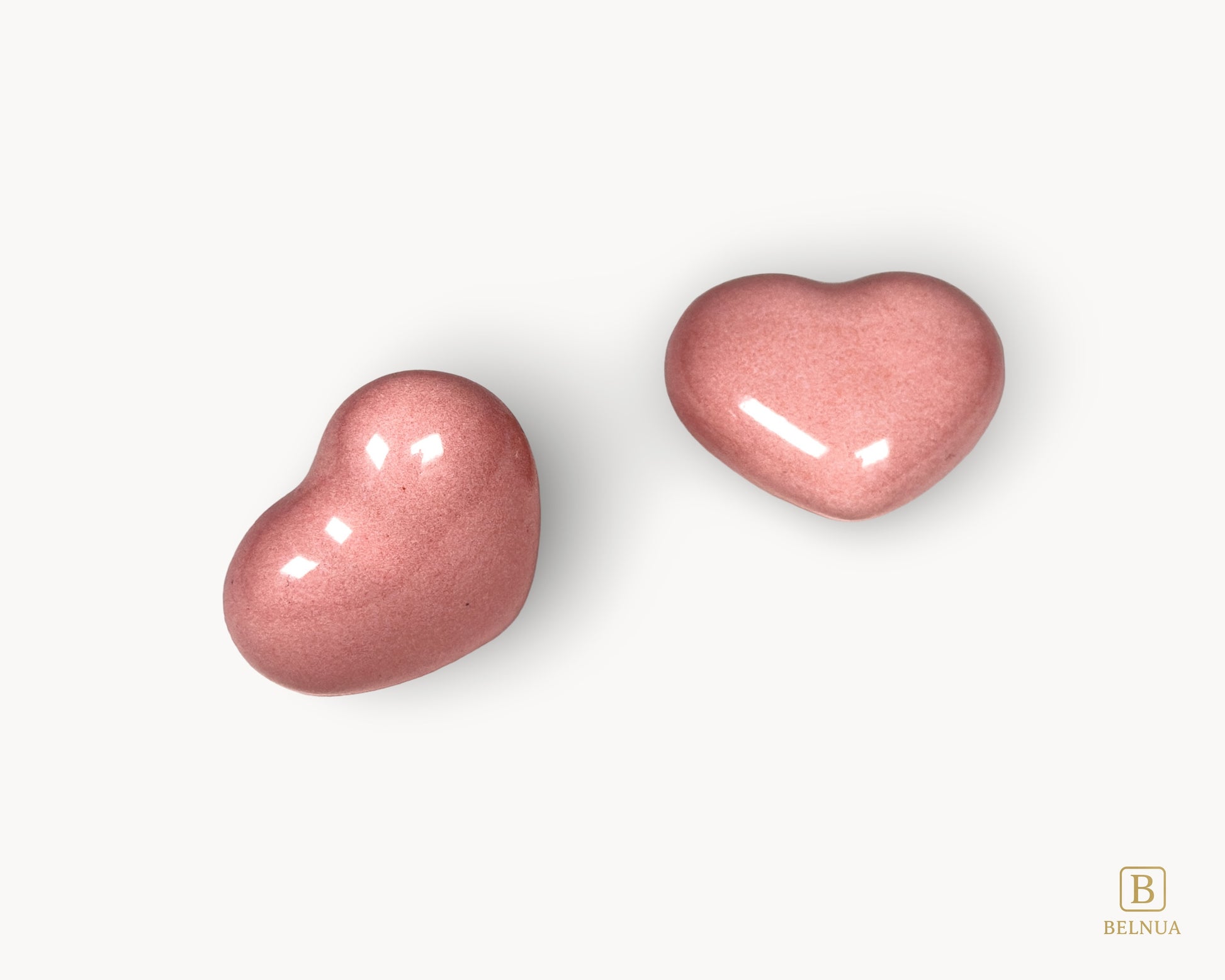 Minimal composition featuring Belnua Veyla pink porcelain heart knobs on a neutral background.