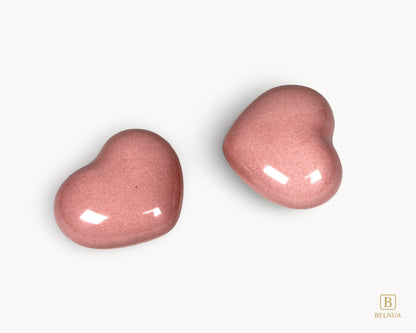 Two pink porcelain heart knobs from Belnua Veyla shown in an angled composition.