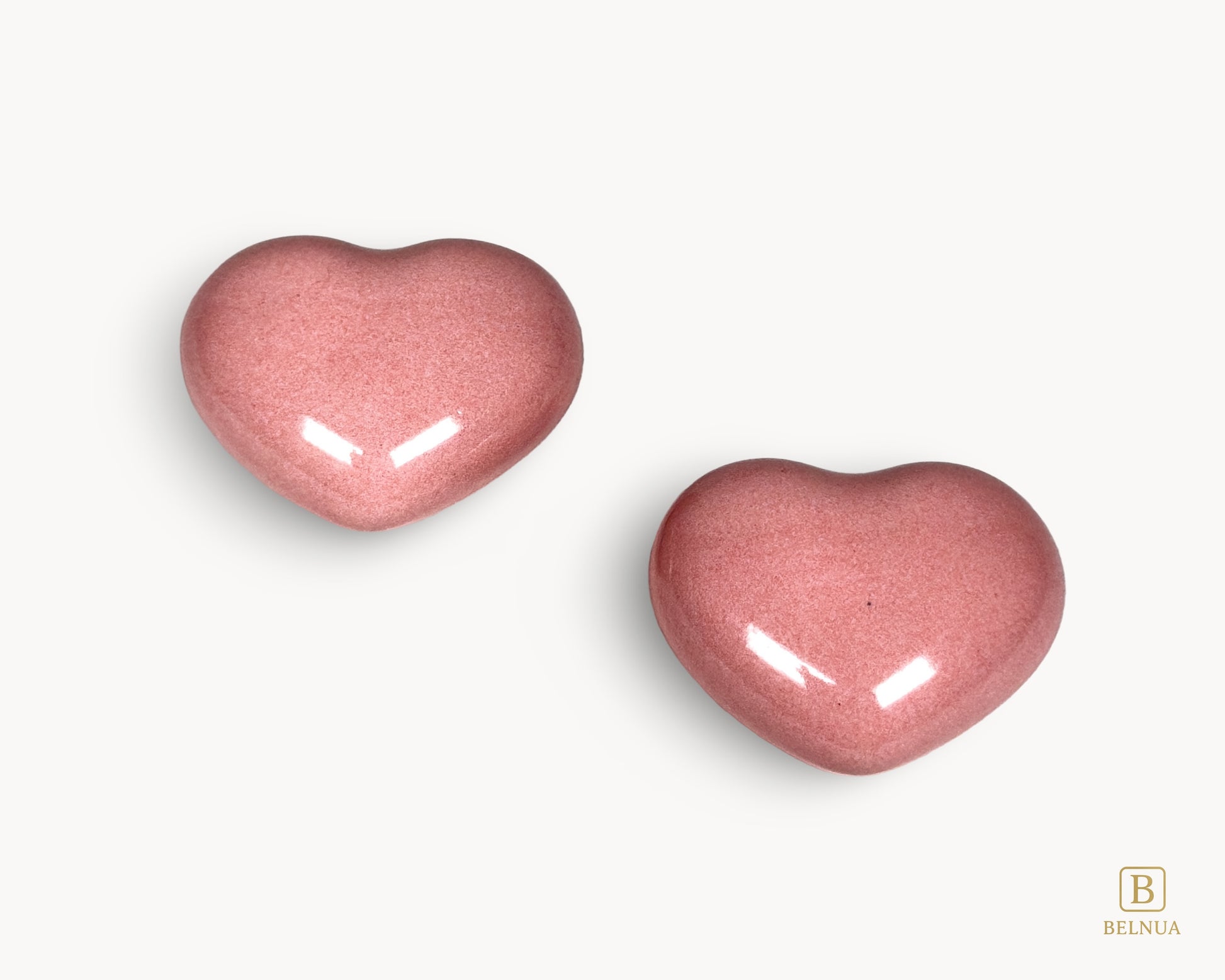 Pair of pink porcelain heart knobs from the Belnua Veyla range displayed on a white background.