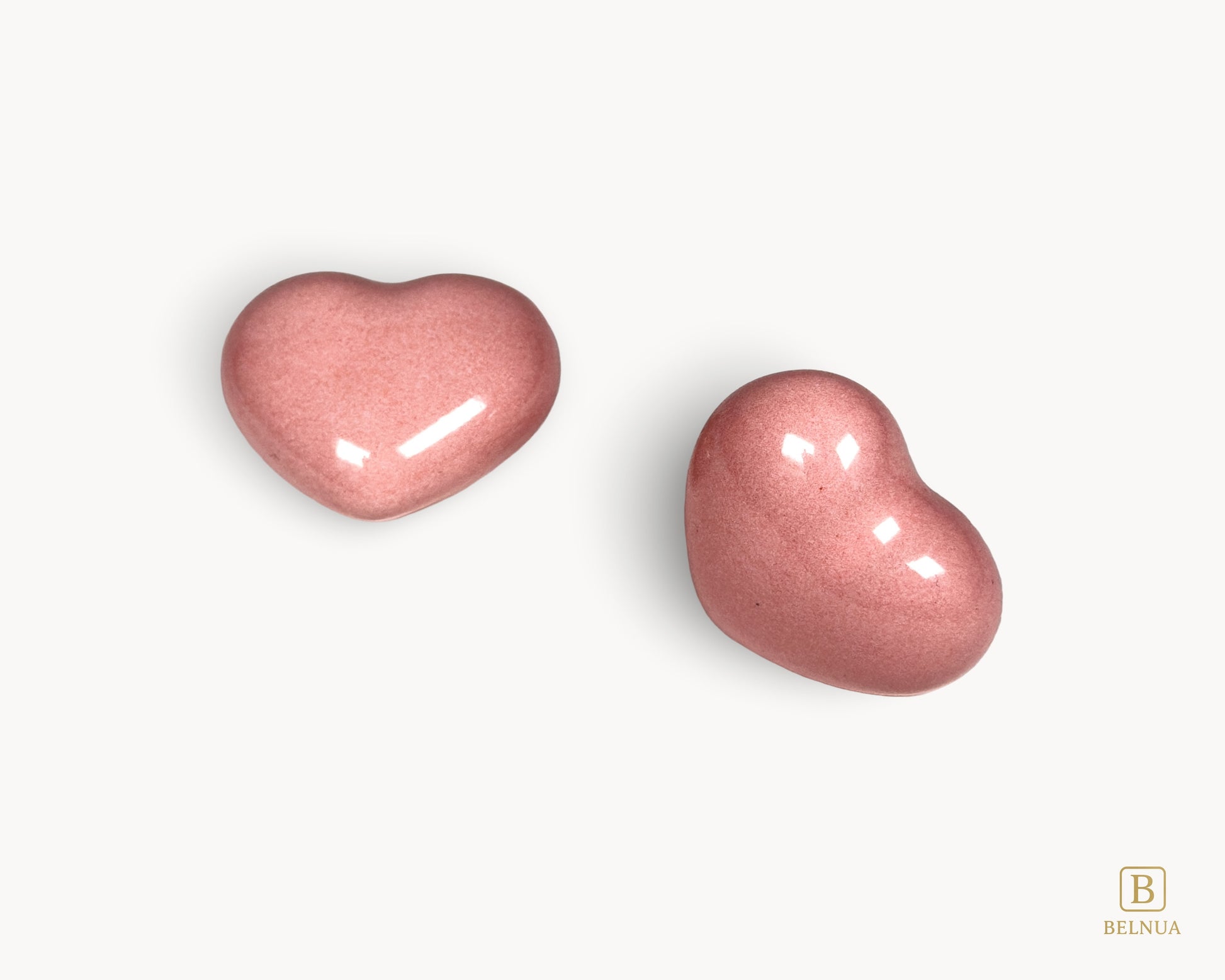 Side profile view of a Belnua Veyla pink porcelain heart-shaped knob.