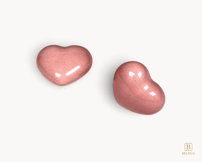 Side profile view of a Belnua Veyla pink porcelain heart-shaped knob.