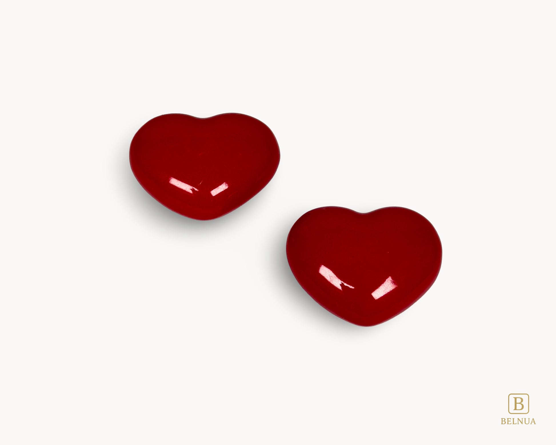 Pair of Belnua Veyla red porcelain heart knobs arranged in flat lay