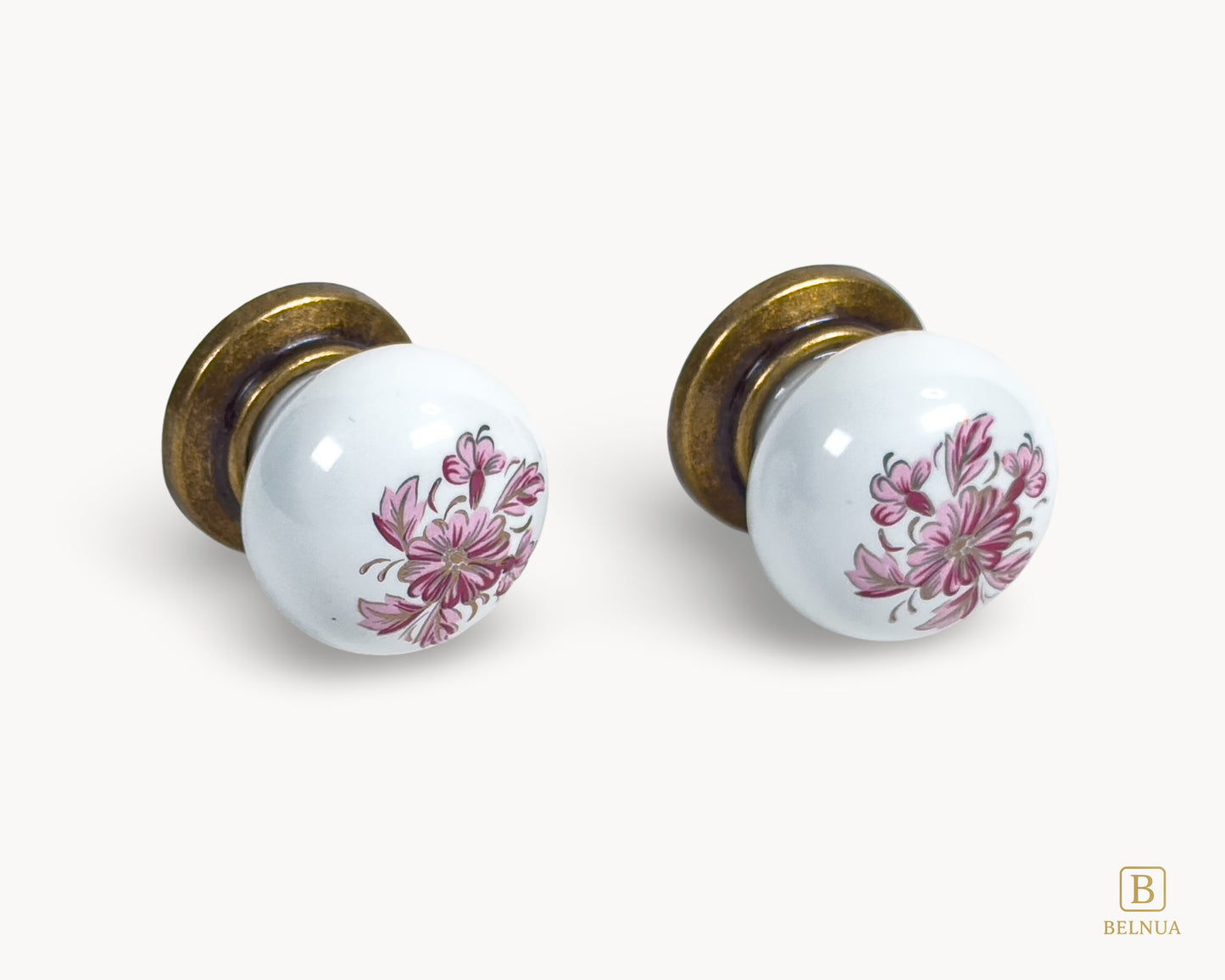 Belnua - Close up front view of ZERRA white porcelain/ceramic knob pair with antique brass base featuring details of petal motif on white cabinet knob