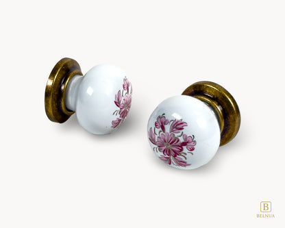 Belnua - Close up front and side view of ZERRA white porcelain/ceramic knob pair with antique brass base featuring petal motif