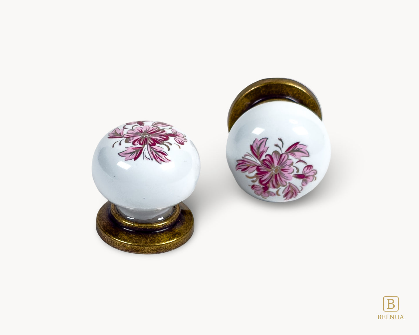 Belnua - Close up front and top view of ZERRA white porcelain/ceramic knob pair with antique brass base and petal motif