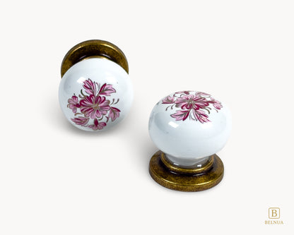 Belnua - Close up front and top view of ZERRA white porcelain/ceramic knob pair with antique brass base and petal motif