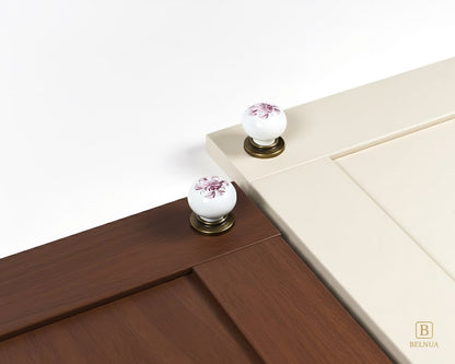 Belnua - Close up top view of ZERRA white porcelain/ceramic knob pair with antique brass base featuring with cashmere and walnut cabinet door