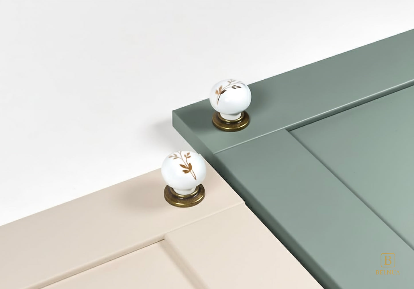 Close-up of cream and sage green kitchen cabinet with Zerra white knobs  | Belnua