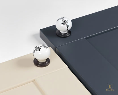 Belnua - ZERRA black and white porcelain knob with midnight blossom motif on cream and navy blue cabinet door