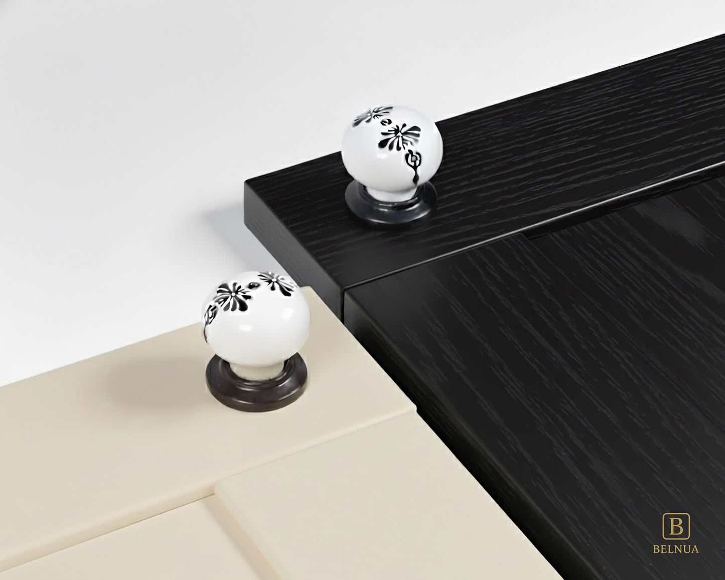 Belnua - ZERRA black and white porcelain knob with midnight blossom motif on cream and black wood grain cabinet door