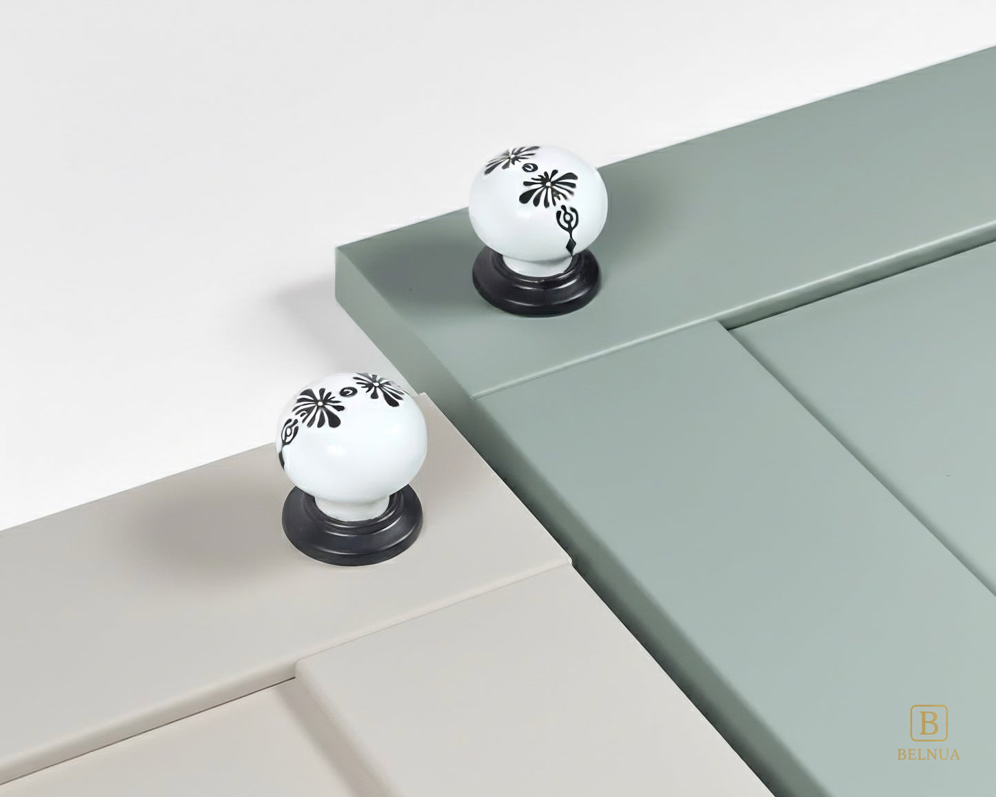 Belnua - ZERRA black and white porcelain knob with midnight blossom motif on light grey and sage green cabinet door