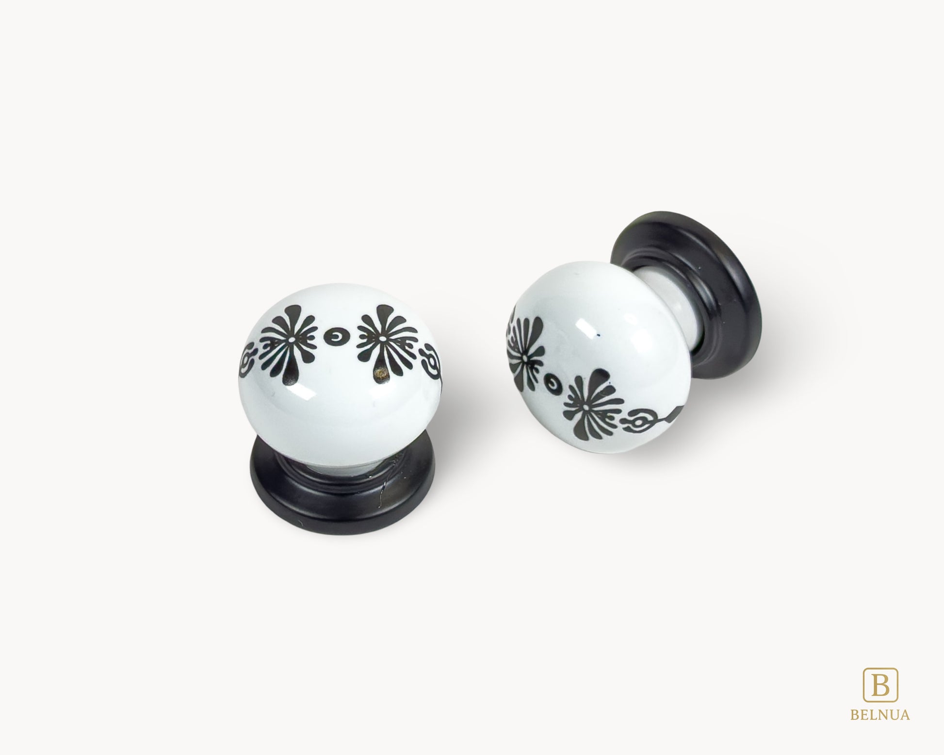 Belnua - Top and front close up view of ZERRA knob with midnight blossom motif on white porcelain/ceramic and matte black base