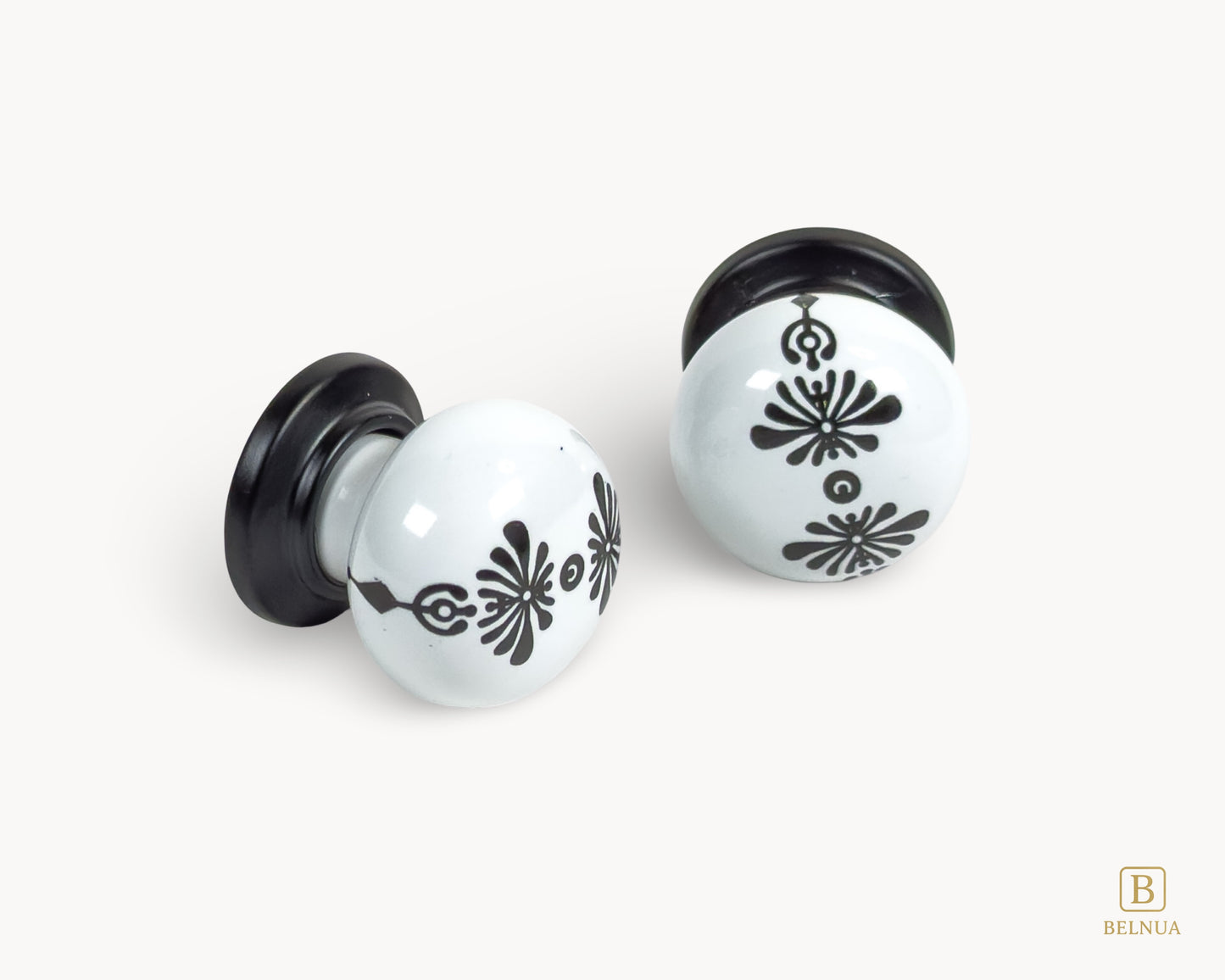 Belnua - Flat lay close up view of ZERRA knob with midnight blossom motif on white porcelain/ceramic and matte black base