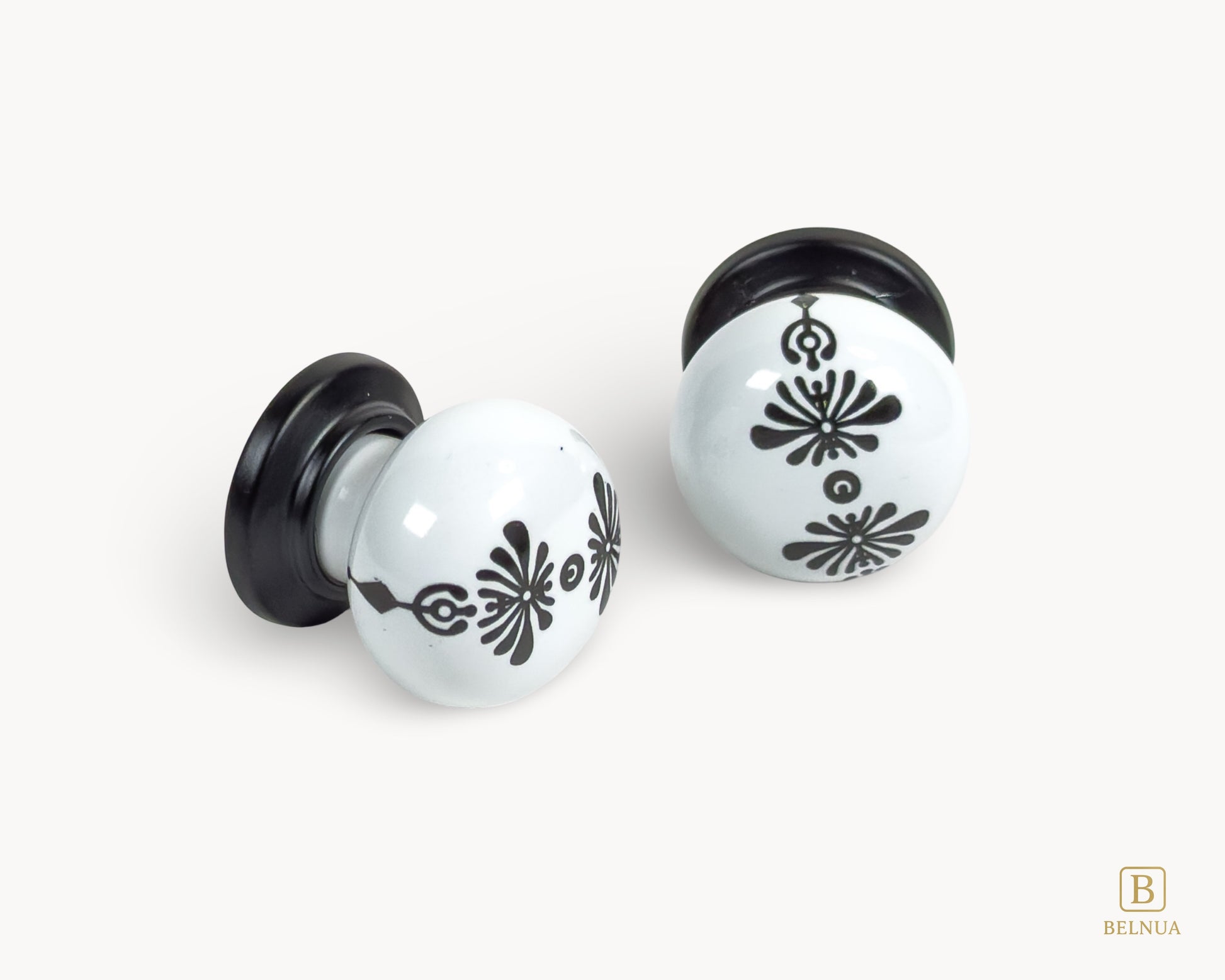 Belnua - Flat lay close up view of ZERRA knob with midnight blossom motif on white porcelain/ceramic and matte black base