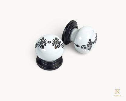 Belnua - Top and right angled view of ZERRA knob with midnight blossom motif on white porcelain and matte black base