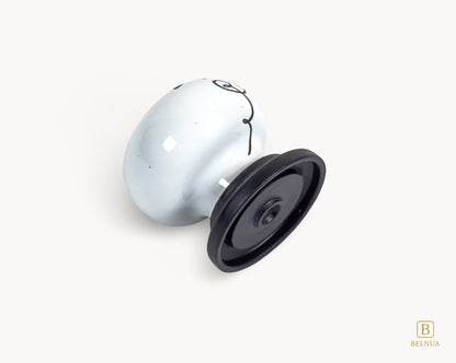 Belnua - Flat lay back close up view of ZERRA white ceramic/porcelain knob showing floral design with matte black base