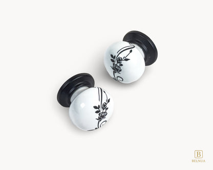 Belnua - Close up flat lay front view of ZERRA white ceramic/porcelain knob showing floral design with matte black base