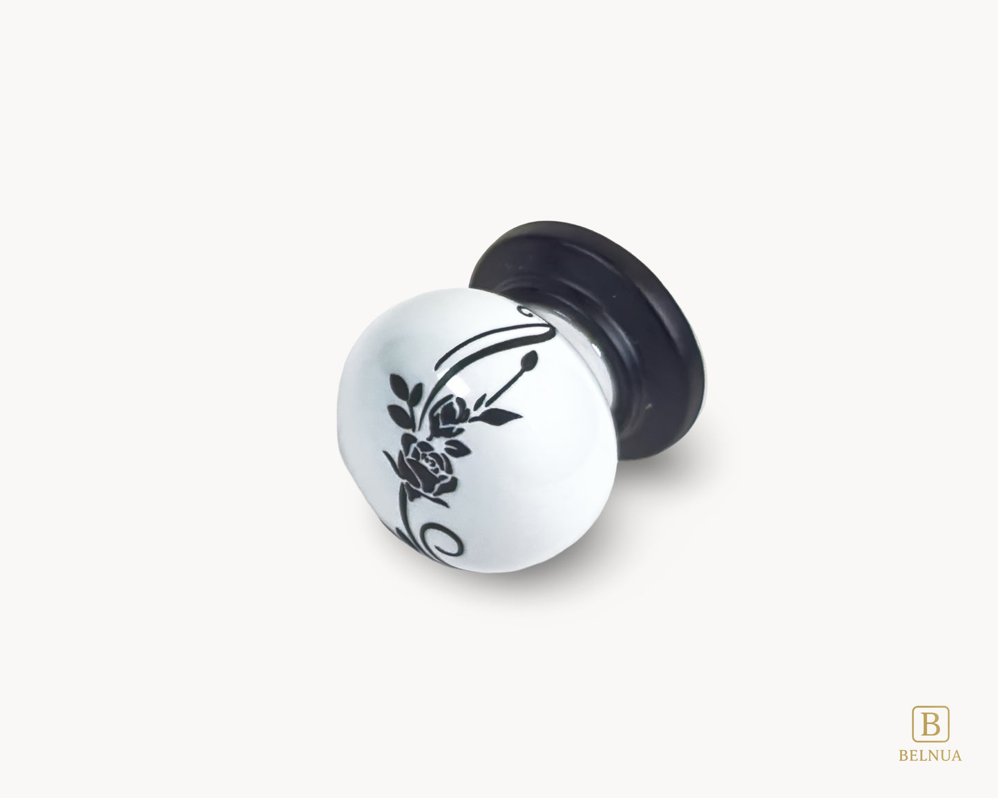 Belnua - Flat lay left close up view of ZERRA white ceramic/porcelain cabinet knob showing floral design with matte black base
