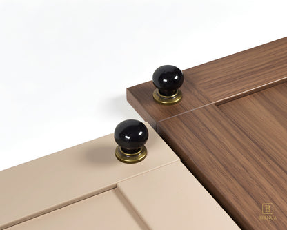 Close-up of a light taupe and walnut cabinet door with black knobs and brass bases from Zerra collection | Belnua