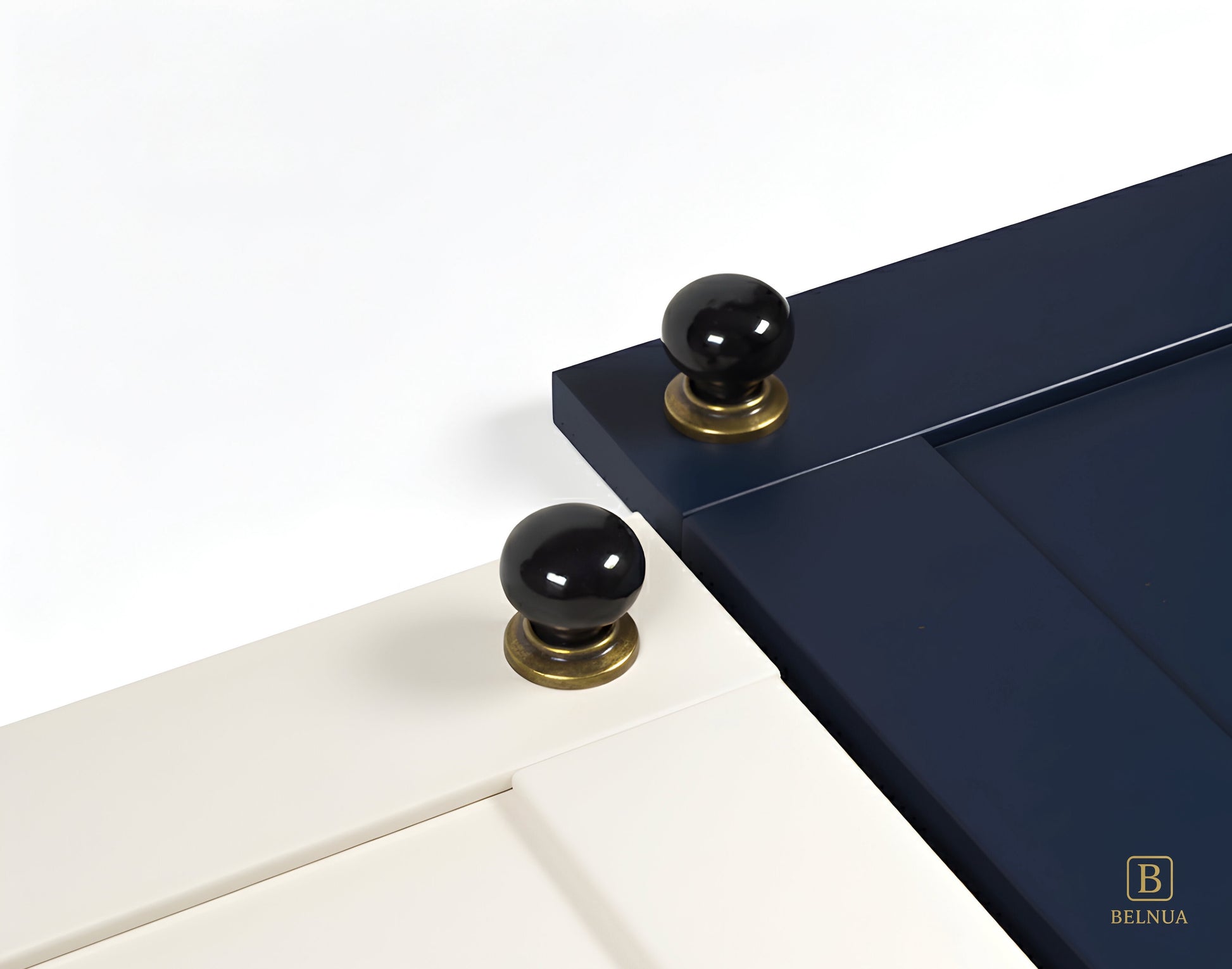 Close-up of a porcelain white and navy cabinet door with black knobs and brass bases from Zerra collection | Belnua