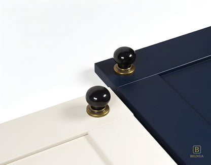 Close-up of a porcelain white and navy cabinet door with black knobs and brass bases from Zerra collection | Belnua
