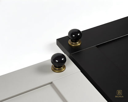 Close-up of a light grey and black cabinet door with black knobs and brass bases from Zerra collection | Belnua