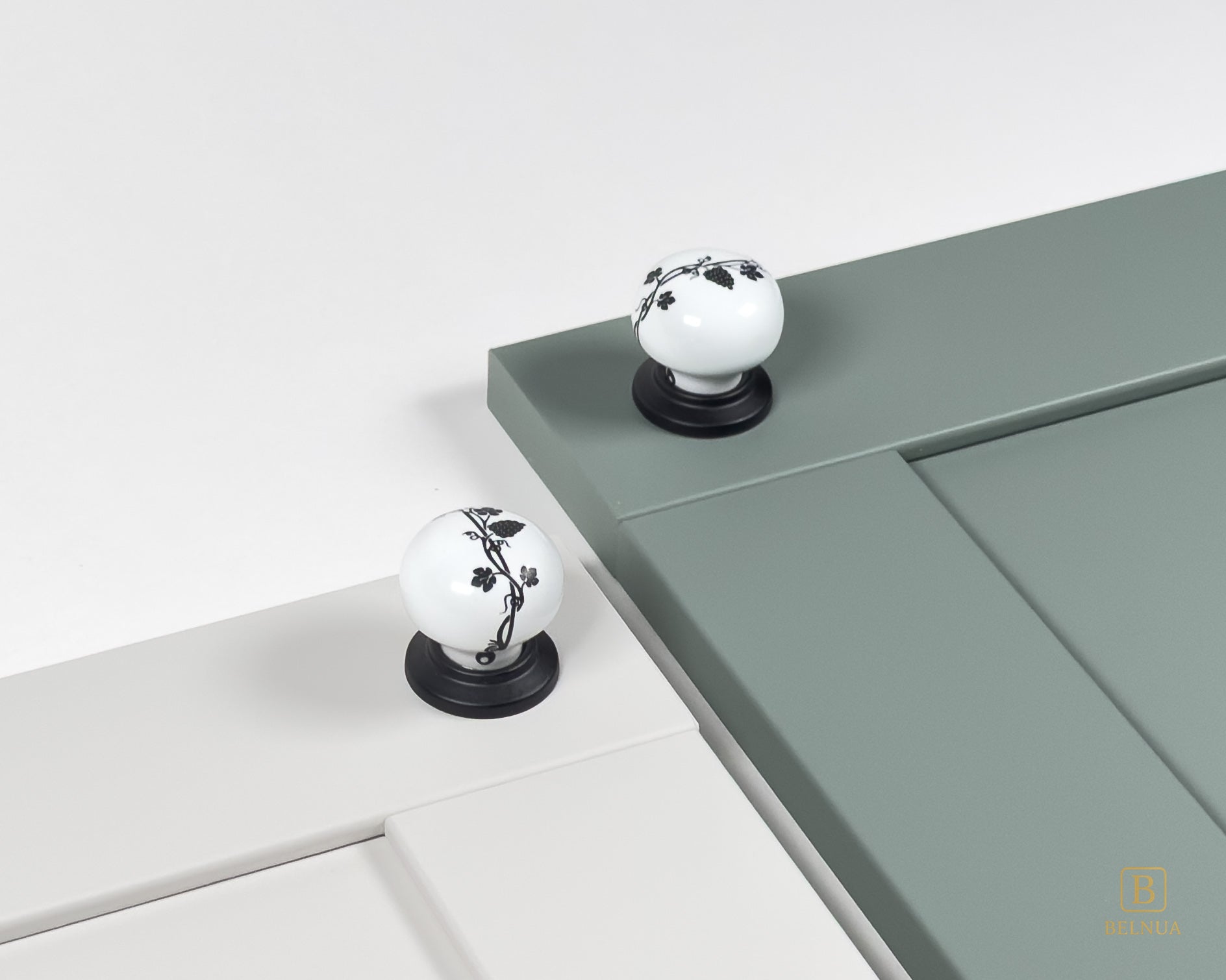 Belnua - Styled cream and sage green cabinet door featuring ZERRA black leaf porcelain knob