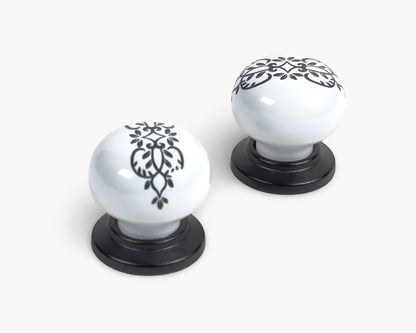 Belnua - Two white ceramic cabinet knobs with black decorative patterns 