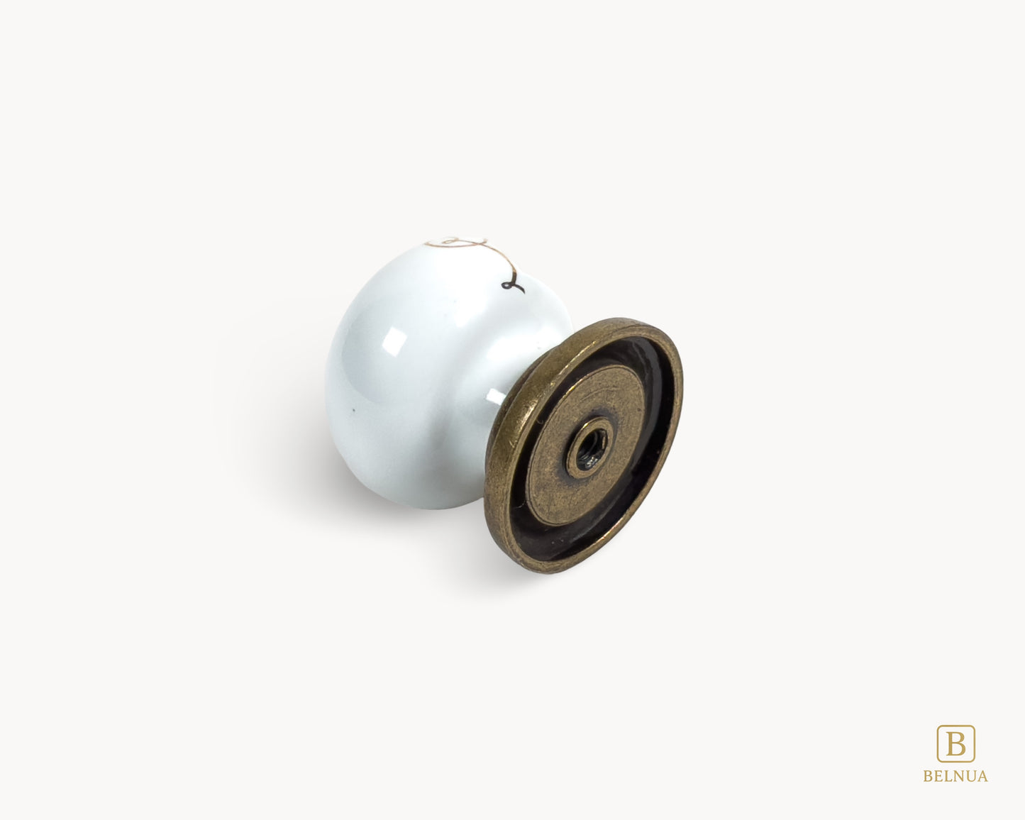 Belnua - Flat lay back view of ZERRA white ceramic/porcelain knob with golden scroll motif and antique brass base
