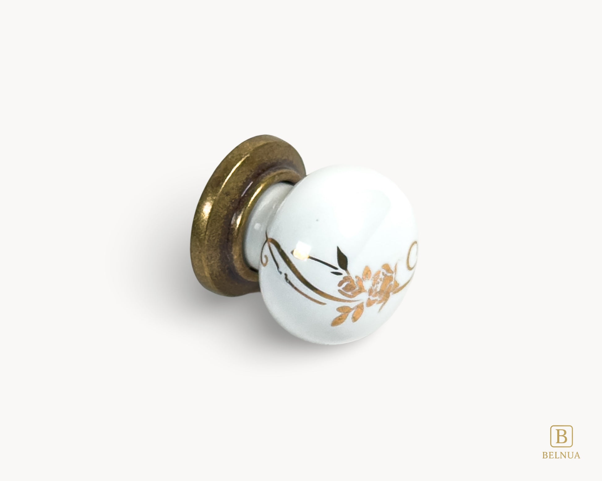 Belnua - Flat lay right view of ZERRA white ceramic/porcelain knob with golden scroll motif and antique brass base