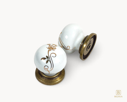 Belnua - Top and back flat lay view of ZERRA white ceramic/porcelain knob with golden scroll motif and antique brass base